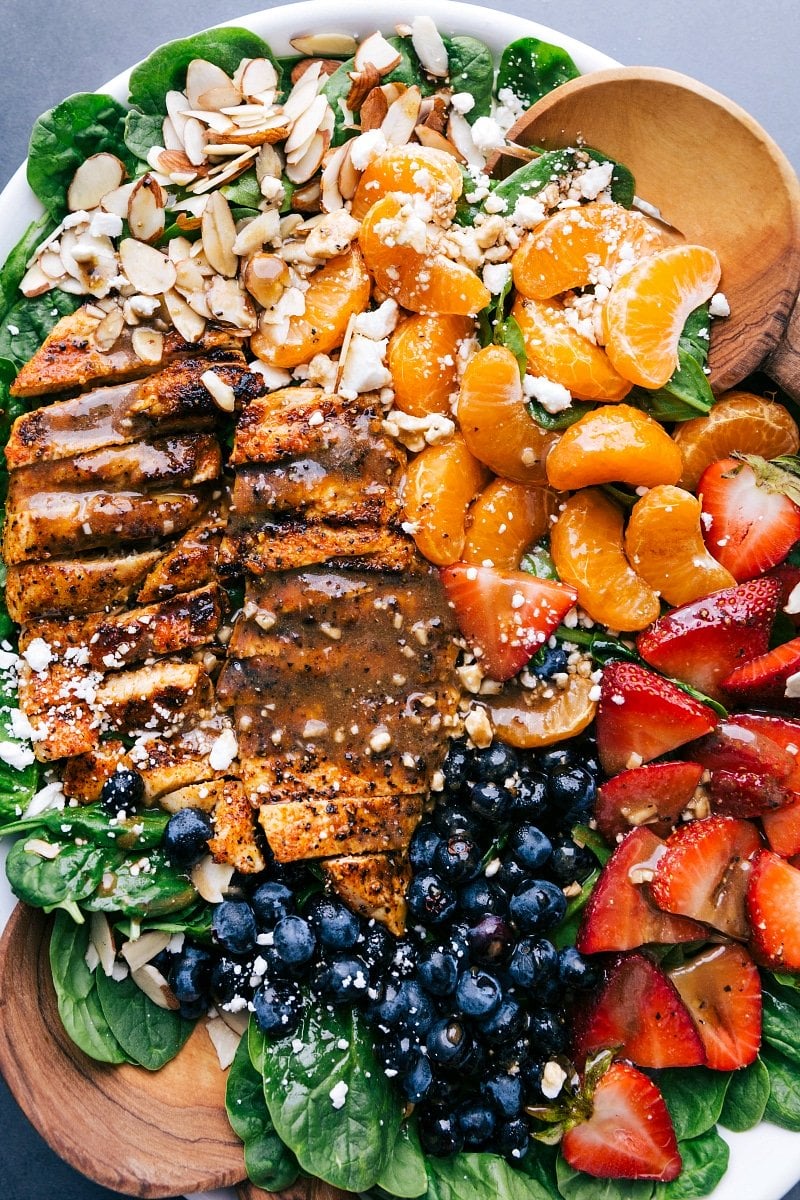 Deliciously Healthy Spinach Chicken Salad: Perfect Blend of Chicken, Spinach, Fruits, Dressing, and Nuts Completed spinach chicken salad showcasing sliced chicken, spinach, topped with fruit, dressing, and nuts, epitomizing a healthy and delicious meal.
