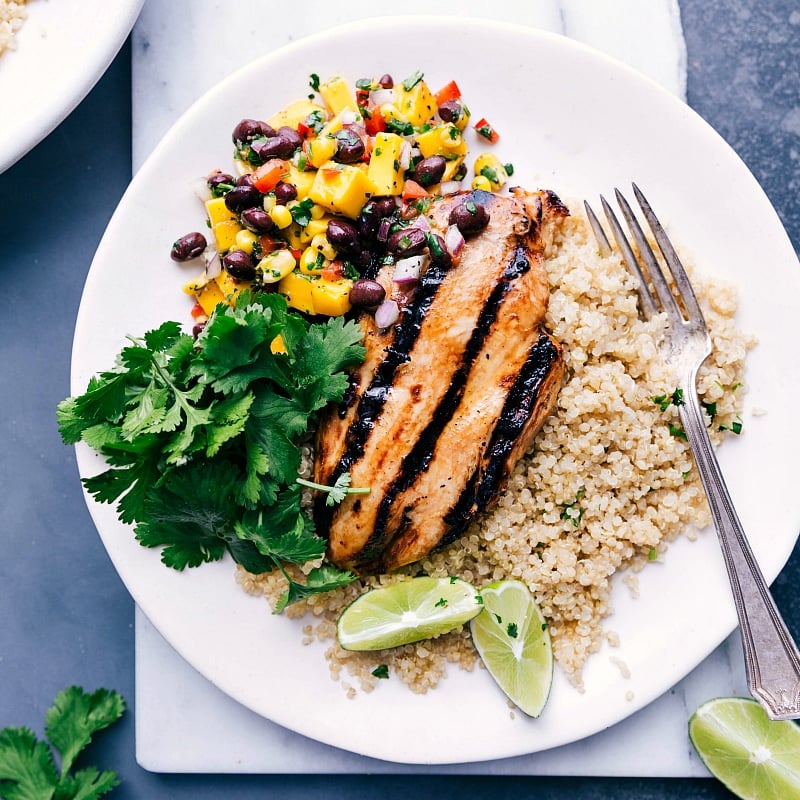 Savory Chicken Quinoa Bowl with Mango Salsa and Rice A delightful chicken quinoa bowl with mango salsa and rice, ready to be enjoyed.