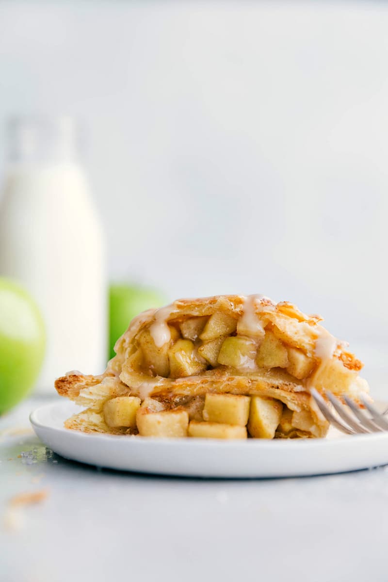 Apple Turnover Recipe with two halves stacked, showing flaky layers and apple filling.