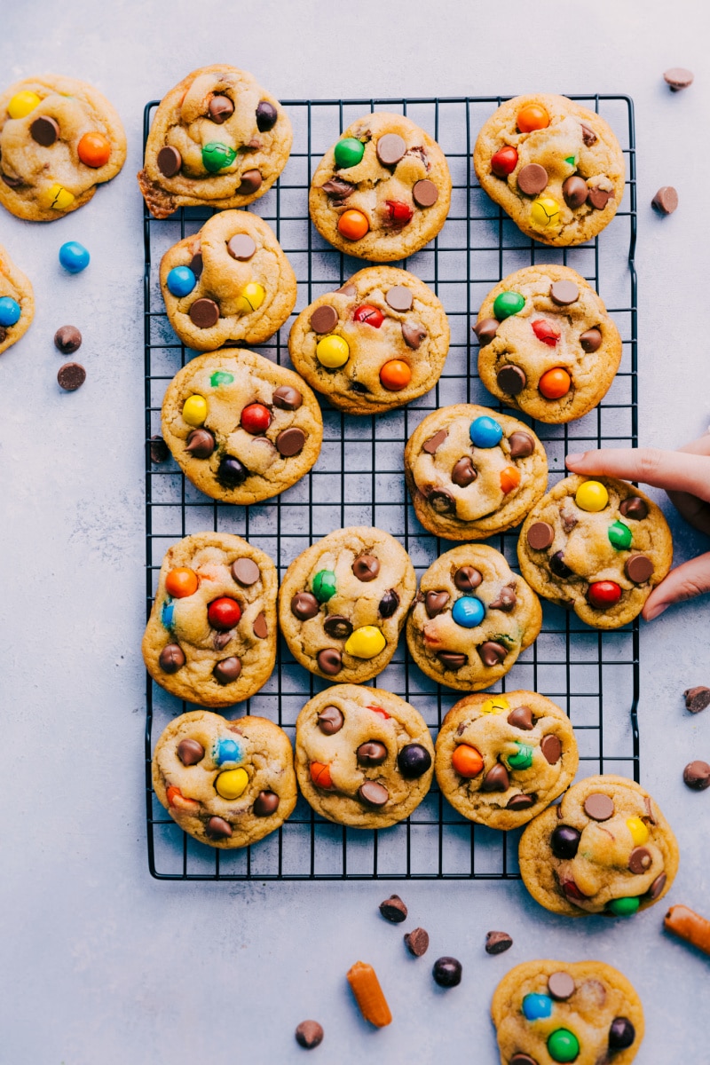 Big, soft and chewy, Caramel Stuffed Cookies with M&M's, chocolate chips, and an ooey-gooey caramel center! Plus all the tips and tricks you need to make these taste (and look) like they're straight from a bakery! Recipe via ChelseasMessyApron #dessert #m&m #treat #best #quick #easy #simple #caramel #stuffed #cookies Overhead image of Caramel StuffedCookies