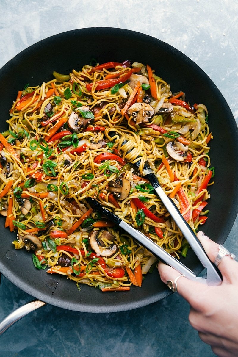 Ready-to-Serve Chow Mein - Loaded with Veggies and Delicious Sauce Chow Mein with tongs, ready to be served, filled with veggies and coated in a delicious sauce.