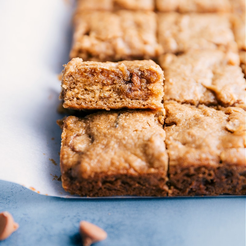 These nutritiousย peanut butter banana bars are made with overripe bananas, peanut butter, and honey. These fudge-like, chewy bars can be made in one bowl and don't require any stops to a special health foods grocery store. Recipe via chelseasmessyapron #dessert #best #quick #easy #simple #healthy #whole #clean #baked #peanutbutter #banana #bars Up close image of the peanut butter banana bars ready to be eaten