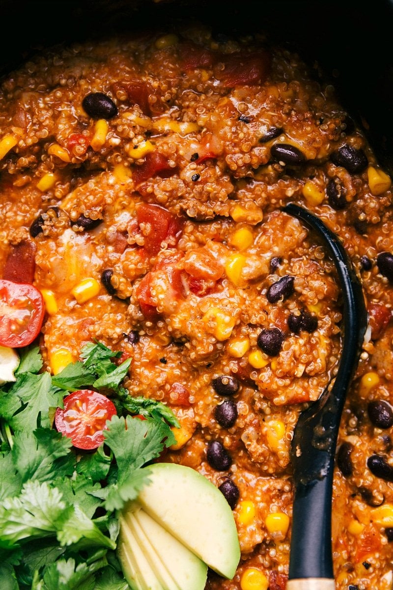 Hearty Enchilada Quinoa Crockpot Meal Ready to Enjoy Finished enchilada quinoa dish in a crockpot, rich and flavorful, with a spoon nestled inside, ready for serving.