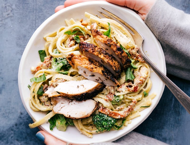 Delicious Creamy Chicken Pesto Pasta with Fresh Rotisserie Chicken Bowl of creamy chicken pesto pasta with fresh rotisserie chicken on top, ready to be enjoyed.