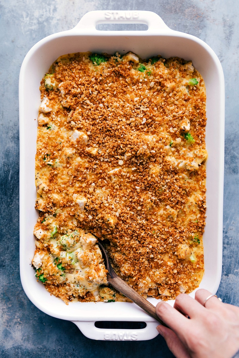 Chicken Poppy Seed Casserole just out of the oven with a spoon scooping out a portion.
