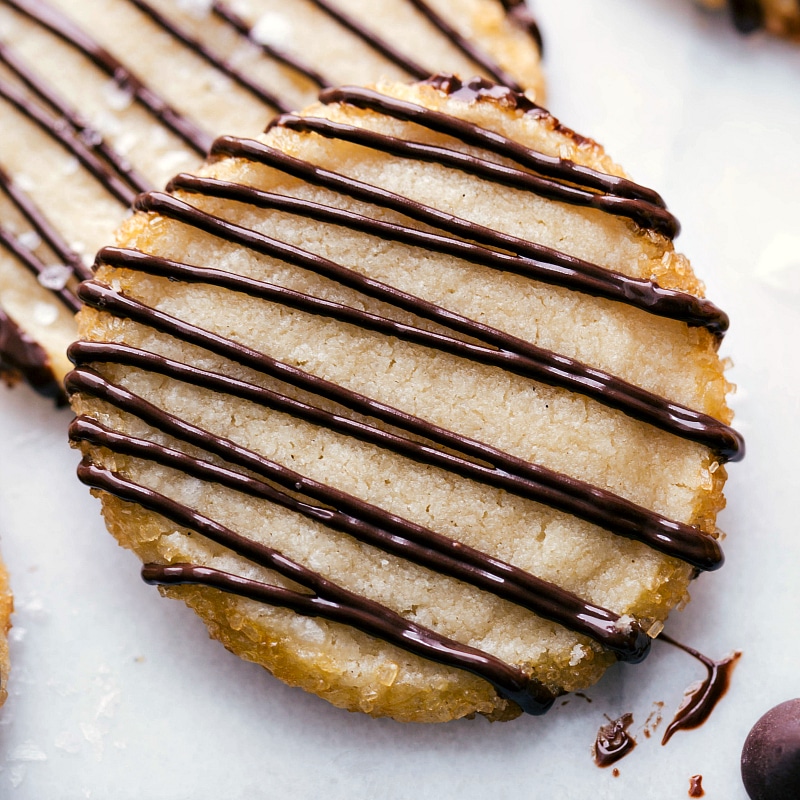 Irresistible Shortbread Cookies with Tempting Chocolate Drizzle Shortbread cookies adorned with a luscious chocolate drizzle.