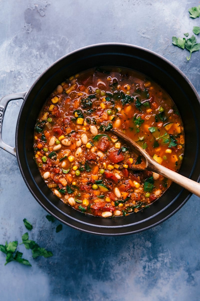 Steaming Pot of Hearty Minestrone Soup Ready to Serve Pot of finished meal, brimming with vegetables, with a big wooden spoon.