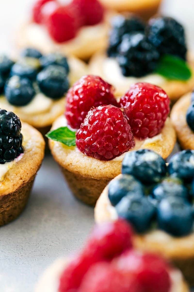 Delightful Mini Fruit Tarts Garnished with Berries and Mint Mini fruit tarts recipe topped with raspberries, blueberries, blackberries, and fresh mint.