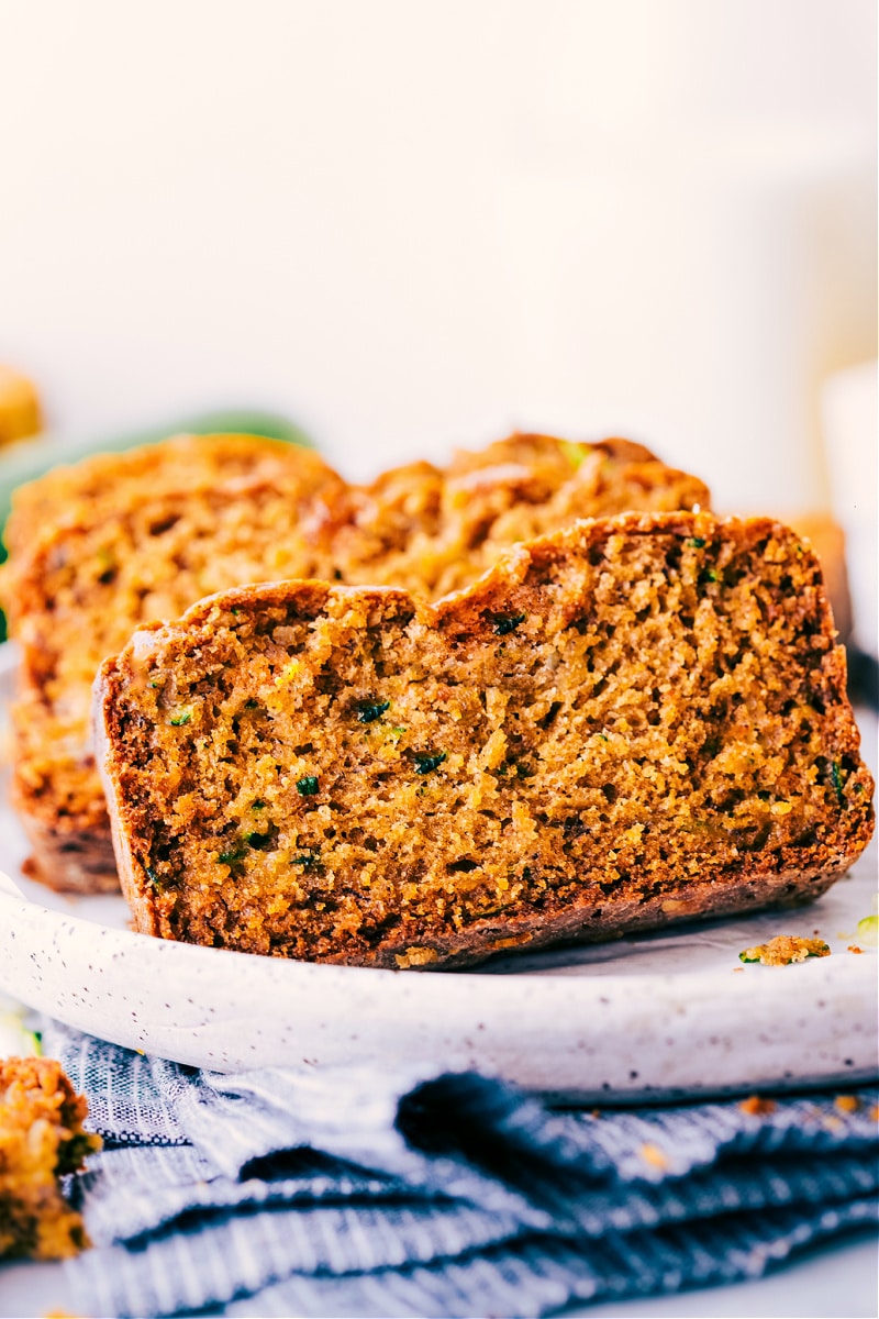 Healthy Zucchini Bread! This bread utilizes better-for-you ingredients -- less sugar than most zucchini breads, Greek yogurt, overripe banana, coconut oil, blended up oats, and loads of zucchini of course! We make this bread in two bowls -- no stand or hand mixers required. Recipe via ChelseasMessyApron #breakfast #quick #easy #simple #healthier #brunch #healthy #zucchini #bread Process shots-- slices of Healthy Zucchini Bread