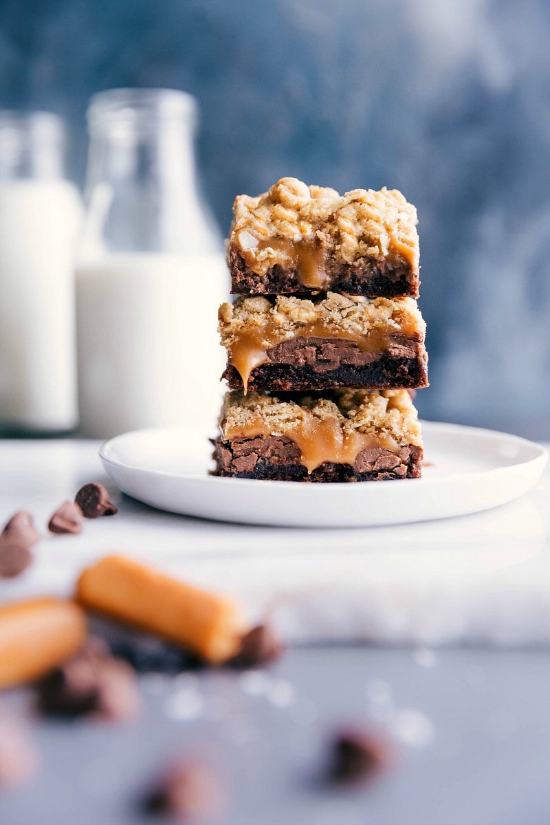 Stacked Brownie Cookie Bars with Oozing Caramel Center Brownie cookie bars stacked, with caramel oozing out from the center layers.