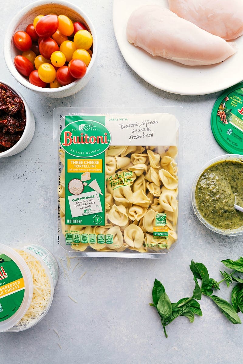 You'll love this one-pot, easy and quick Pesto Chicken Tortellini with sun-dried tomatoes and fresh basil! Recipe via chelseasmessyapron #recipes #pastasalad #greencolors #pesto #chicken #sundriedtomatoes Process shot-- image of all the ingredients that go into Pesto Chicken Tortellini.