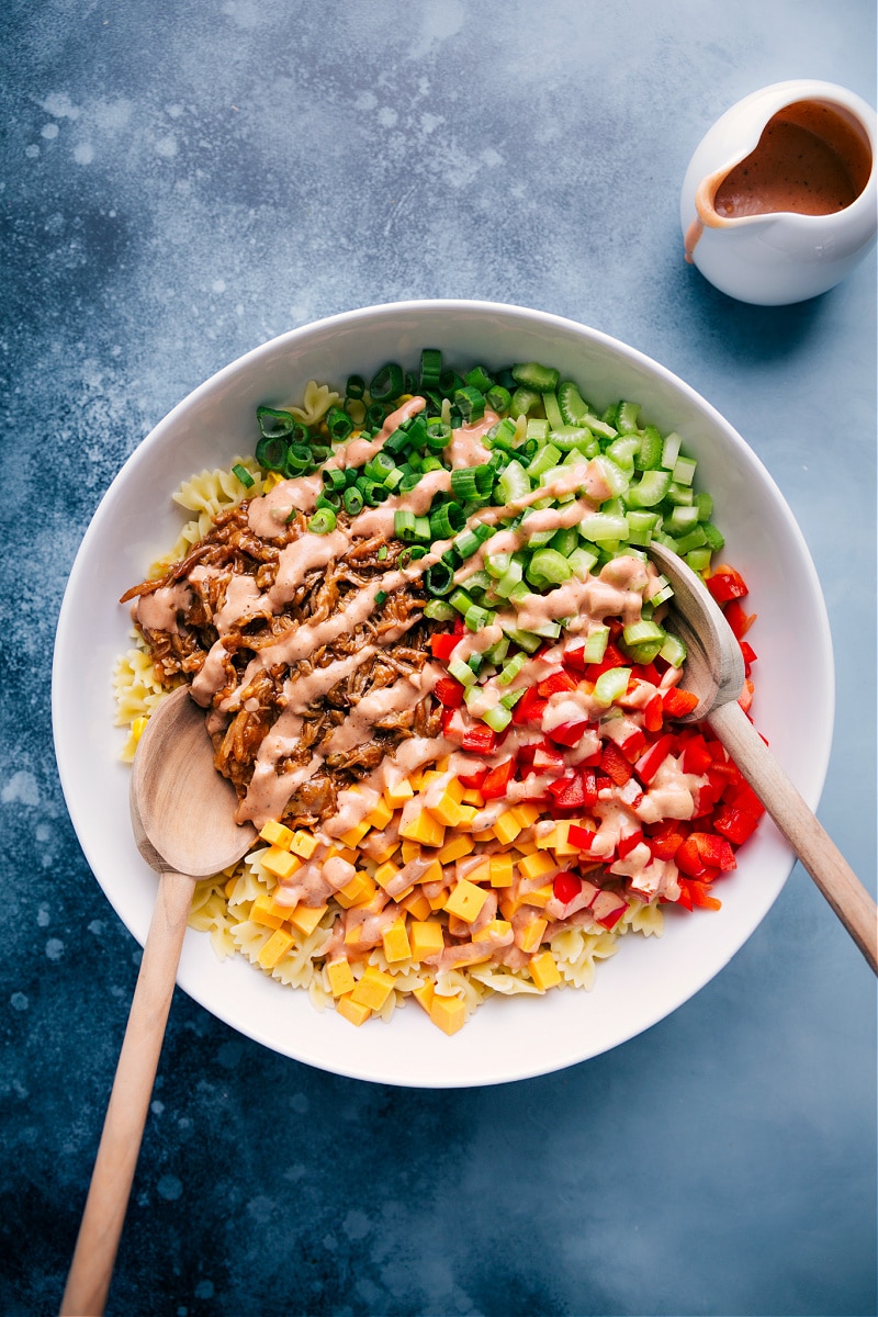 BBQ Pasta Salad in a large bowl drizzled with the creamy dressing.