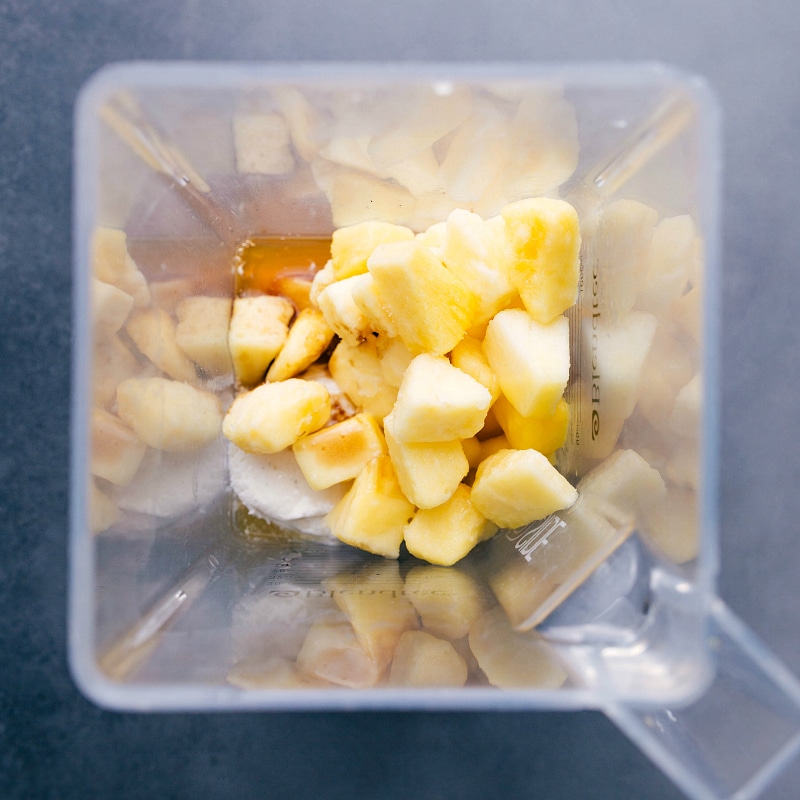 Ready to Blend: Fresh Pineapple and Ingredients for Homemade Copycat Dole Whip. Blender full of frozen pineapple and other ingredients.