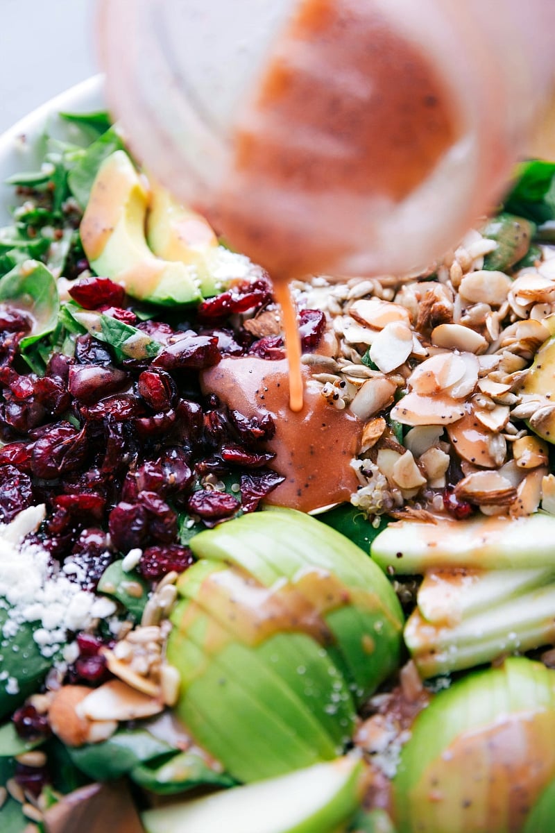 Adding Dressing to Salad Ingredients Drizzling dressing on top of the rest of the ingredients.