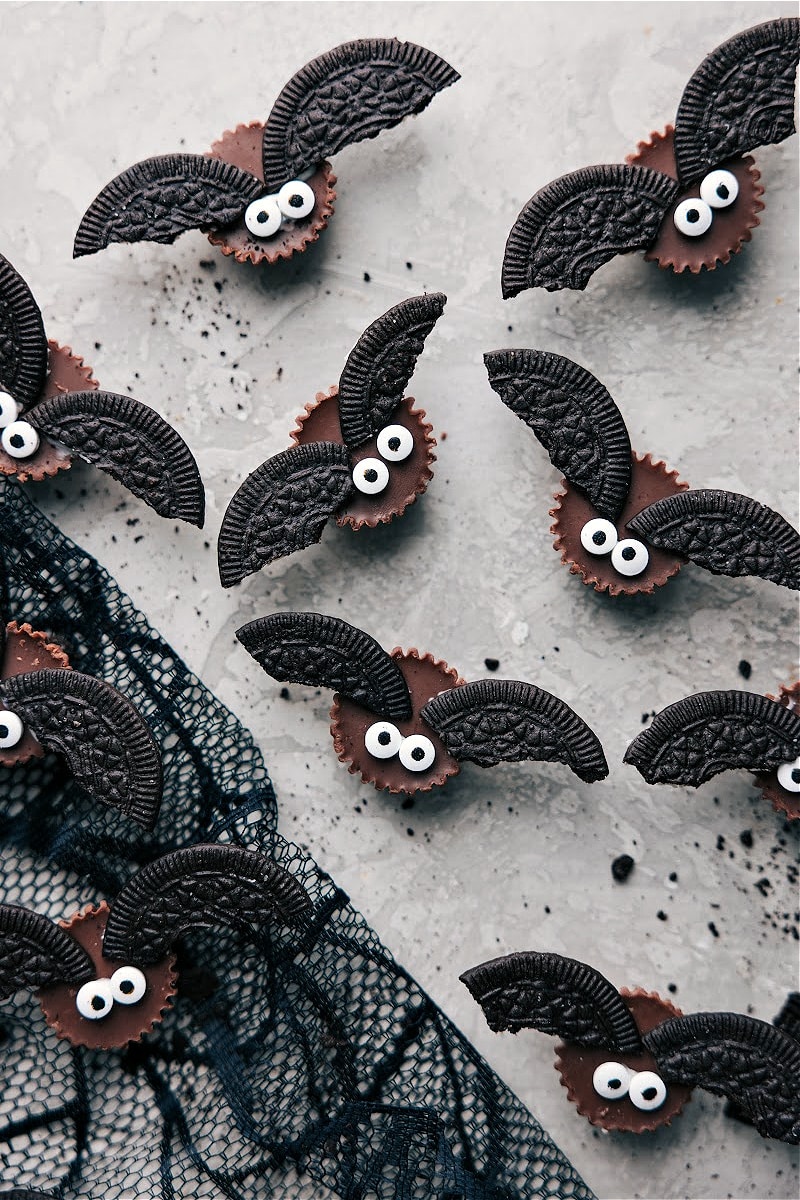 With just four ingredients or less, you can make Monster Eyeballs, Witches Hats, Witches Brooms, and Bat Bites. Simple, tasty, and no baking needed! Let's get this Halloween party started! Recipe via chelseasmessyapron #dessert #best #quick #simple #treat #spooky #easy #halloween #treats Overhead image of Bat Treats that go in this Easy Halloween Treats series