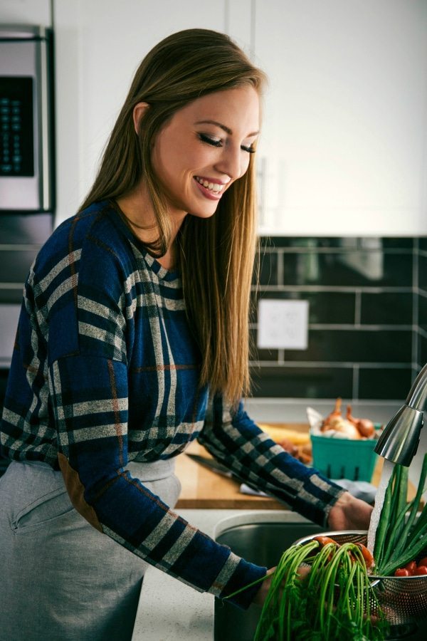 Vegetables Being Prepped for Thanksgiving Dinner Chelsea rinsing vegetables at the sink for Thanksgiving dinner.