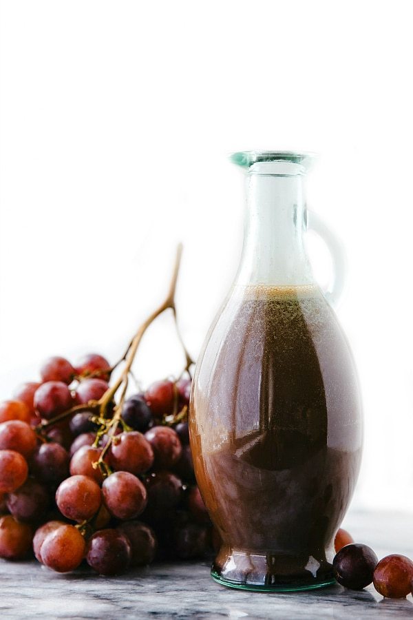 Cherry Balsamic Salad Dressing with Fresh Grapes Cherry balsamic salad dressing in a container, accompanied by fresh grapes for a delicious salad.