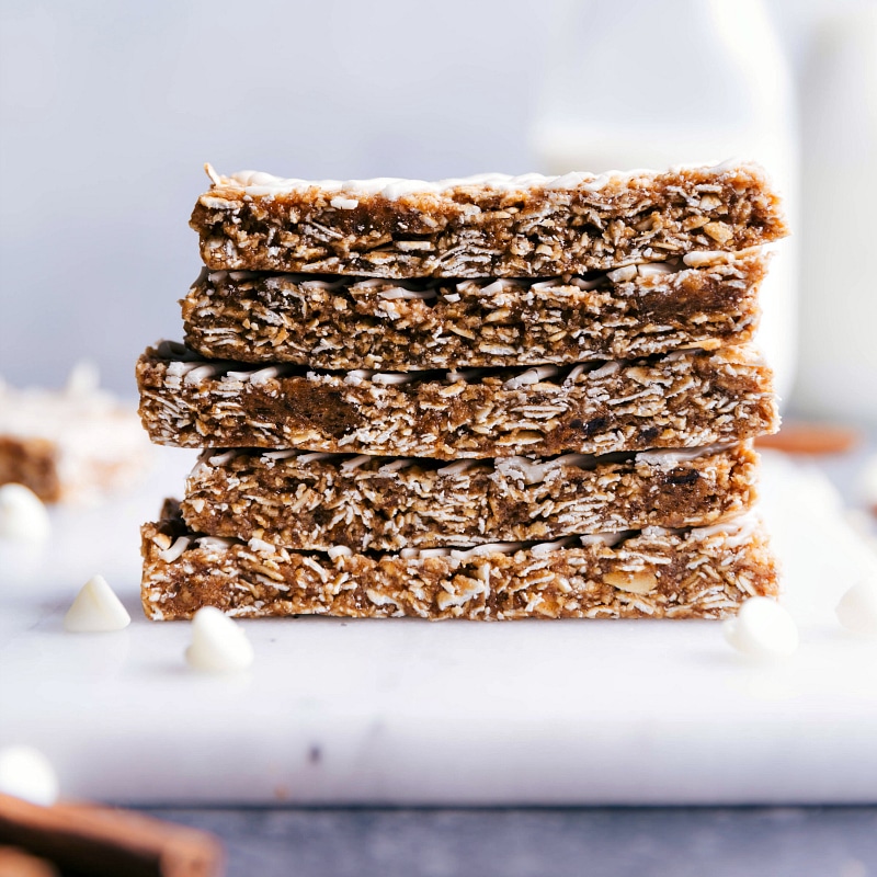 These Oatmeal Granola Bars are made to taste like an iced oatmeal cookie! Recipe via ChelseasMessyApron #quick #easy #snack #best #simple #glaze #oats #healthy #kidfriendly #oatmeal #granola #bars Oatmeal Granola Bars stacked on top of each other