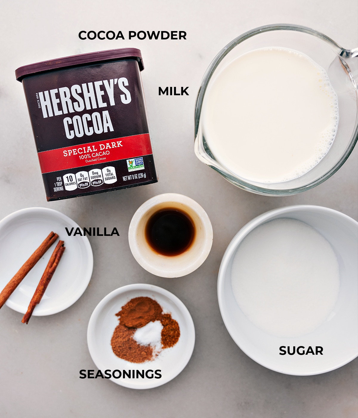 Essential ingredients for crafting luxurious Mexican Hot Chocolate Arrangement of ingredients including milk, rich cocoa powder, and additional elements for the Mexican Hot Chocolate recipe.
