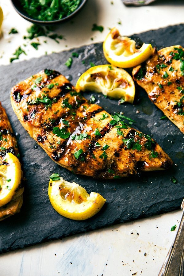 Grilled Chicken Marinade The best grilled chicken marinade, garnished with fresh herbs on top and lemon juice ready to be cut up and enjoyed for added flavor.