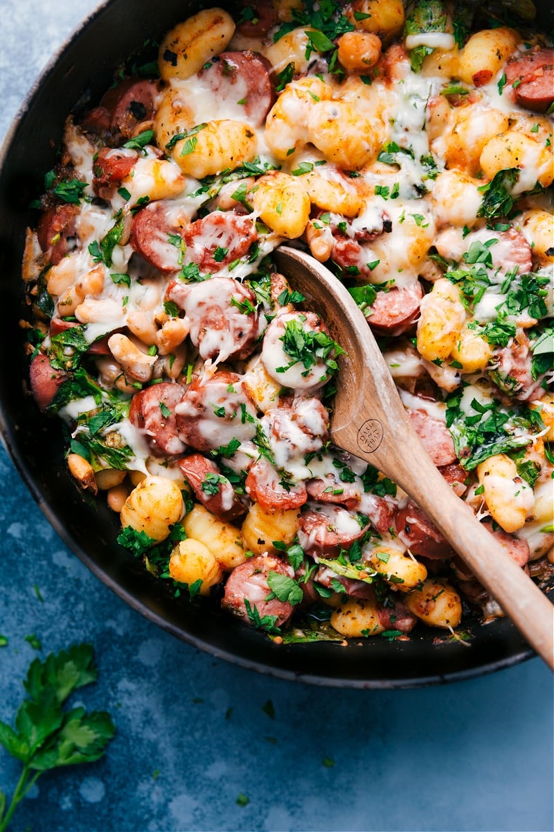 This White Bean Gnocchi combines aromatics, smoked sausage, savory white beans, tender gnocchi, fire-roasted tomatoes, and baby spinach for an explosion of flavor and textures! This nutritious and hearty meal can be prepared in less than 30 minutes and is made in one skillet! Recipe via chelseasmessyapron #dinner #comfort #comfortfood #best #delicious #easy #simple #onepan #whitebean #gnocchi White Bean Gnocchi