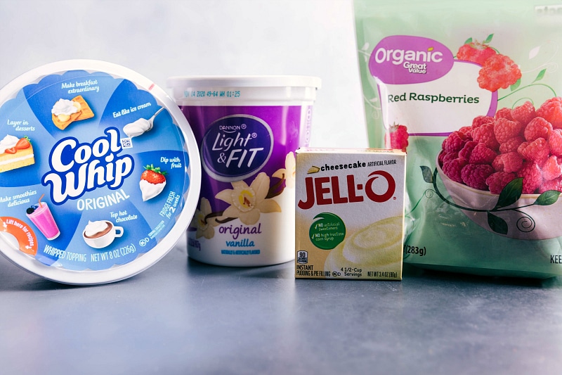 Raspberry Fluff is a simple dessert salad made with only four ingredients with only about ten minutes of prep time! This is the perfect side dish for any occasion! Recipe via chelseasmessyapron #salad #saladcoolwhip #dessert #coolwhip #saladrecipes #withyogurt #recipes #thanksgiving #christmas #easter #raspberry #fluff Photo of the ingredients for Raspberry Fluff.