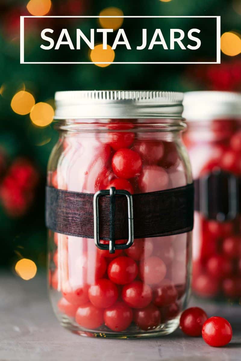 Christmas Mason Jars Santa Edition Santa jars filled with cherry chew sour balls and a black ribbon wrapped around the outside of the jar.