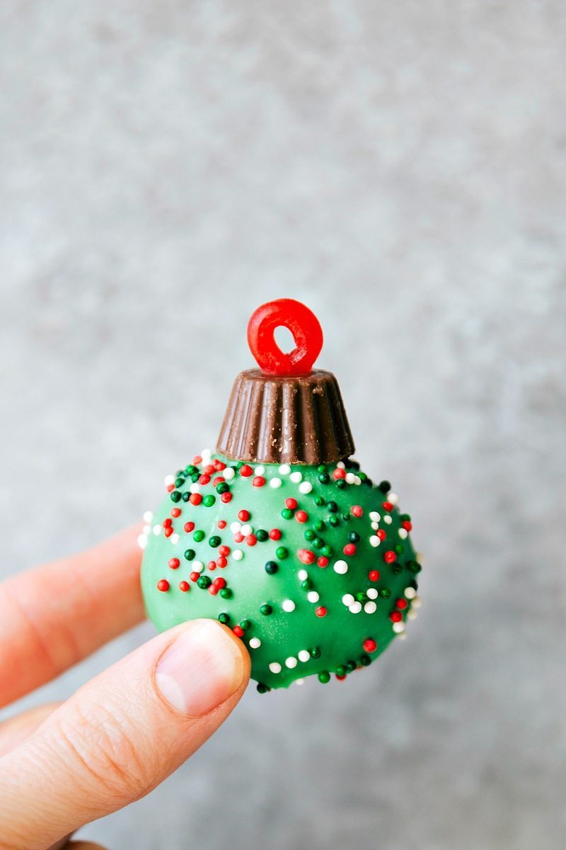 OREO Cookie truffle for Christmas -- Santa's hat, Reindeer, Ornament, Snowman, and Christmas hearts. These easy and delicious Christmas OREO Cookie truffles are perfect for a party, to gift to neighbors, bring into work, or enjoy with your family! Image of one of the ornament treat