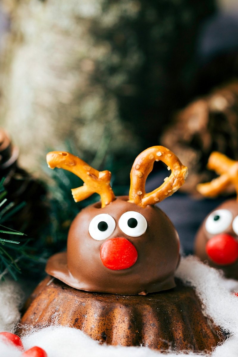 Five different ways to dress up an OREO Cookie truffle for Christmas. These easy and delicious Christmas OREO Cookie truffles are perfect for a party, to gift to neighbors, bring into work, or enjoy with your family! Image of one of the Reindeer Oreo Truffles