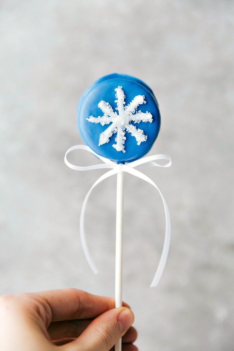 Christmas Oreo Pops: a penguin, snowflake, reindeer, and a candy cane. Video tutorial included! Recipe via chelseasmessyapron #holidays #best #quick #easy #gifts #penguin #dessert #christmas #oreo #pops Image of the snowflake Oreo pop
