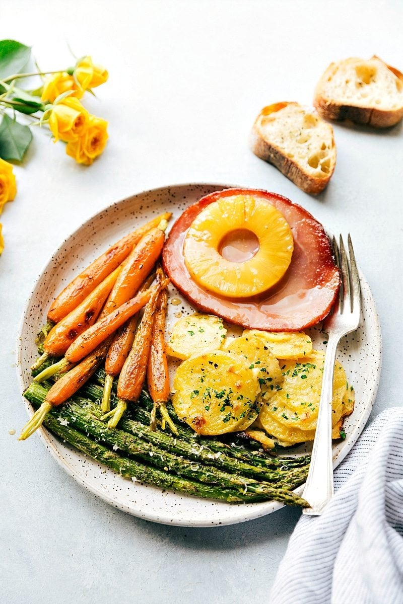 An entire Easter Dinner made in an hour (or less), baked in the oven together, and all on 2 sheet pans!ย The best Easter dinner ideas. Recipe via chelseasmessyapron #sides #menu #recipes #meat Image of the easter dinner on a plate with a fork on the side