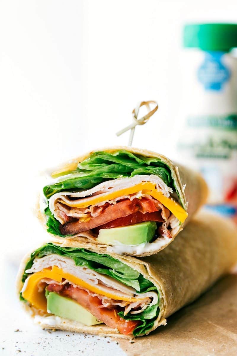 Turkey Wraps that both kids and adults will love. These wraps are great for busy weeknights when you don't have a lot of time to spend in the kitchen, or for a quick lunch when you're on the go. And best of all, they taste absolutely incredible! Packed with smoky deli turkey, sharp Cheddar cheese, fresh lettuce, juicy tomatoes, and creamy avocado, these wraps are the perfect balance of flavors and textures. Recipe via chelseasmessyapron #lunch #quick #easy #simple #best #familyfriendly #kidfriendly #healthy #nobake #kidfriendly #turkey #wraps Up-close image of the lunch ready to be enjoyed