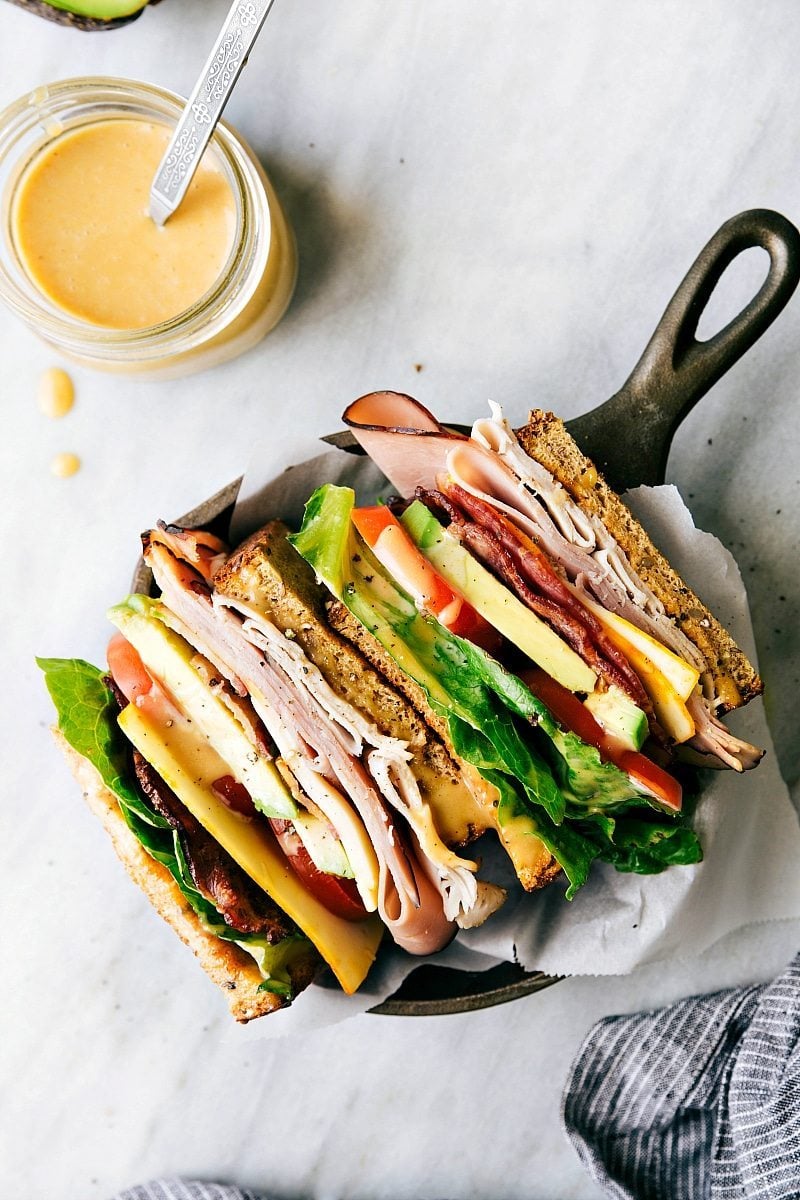 How To Make The Best Honey Bacon Club Sandwich Recipe The club sandwich recipe sliced in half to show the different layers.
