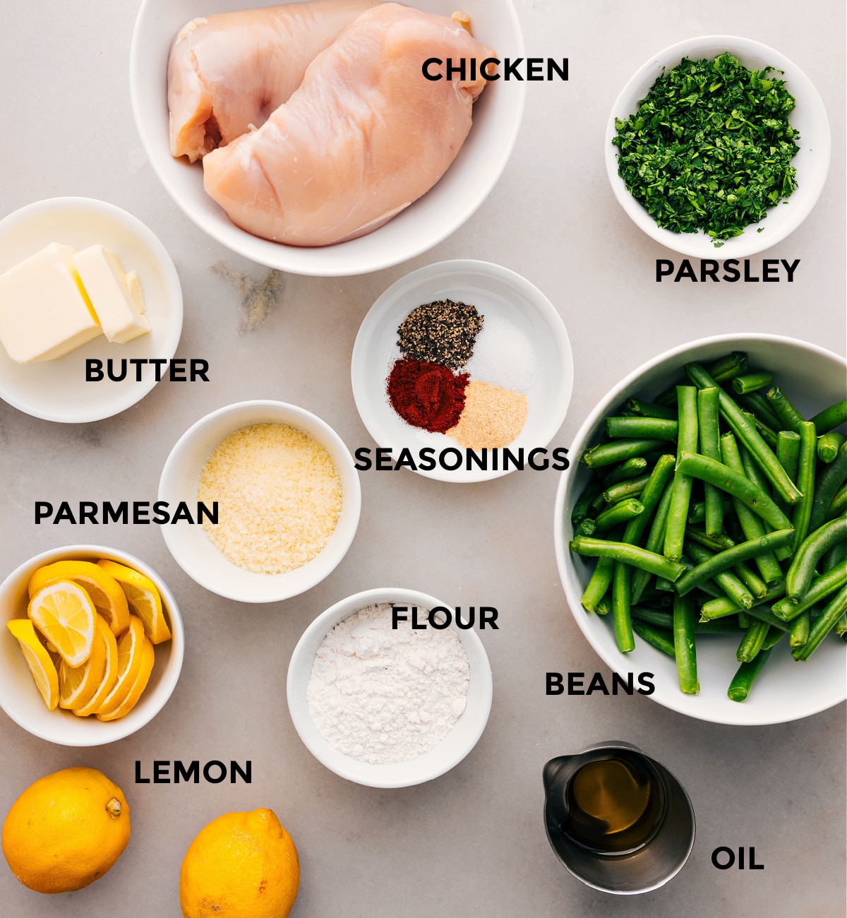 Ingredients In Lemon Parmesan Chicken Prep all the ingredients for this recipe, including the meat, beans, parsley, seasonings, butter, flour, cheese, and lemons, for easy assembly.