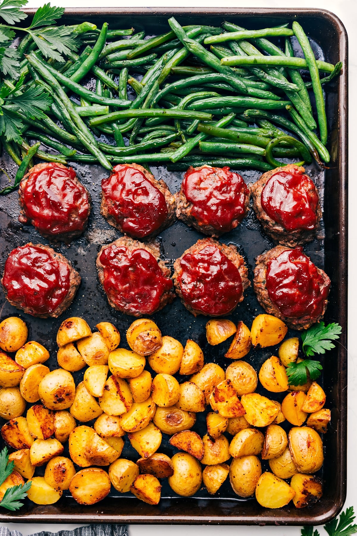 Mini Meatloaf, mashed potatoes, and roasted green beans all get baked together on ONE sheet pan! Recipe via chelseasmessyapron #easy #meat #sheetpan #recipe