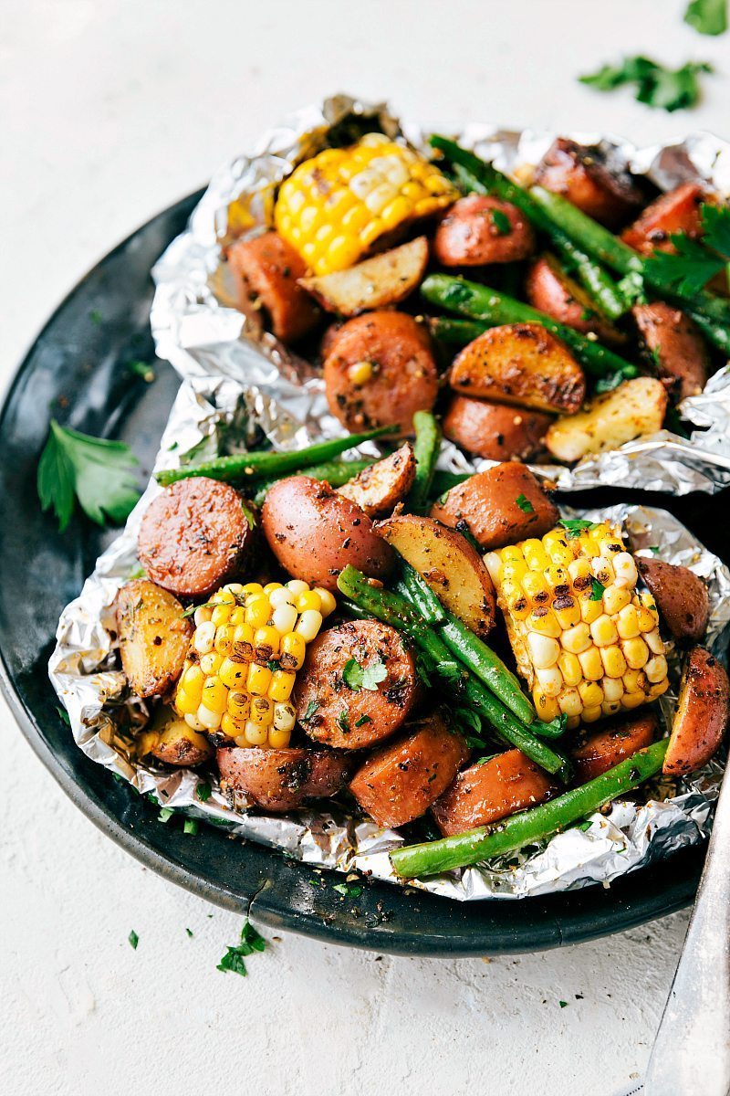 Easy Foil Pack Garlic Butter Sausage & Veggies! Toss everything with a simple (but flavor-packed) seasoning blend, add some butter, and throw these packets on the grill or in the oven. These simple foil pack dinners can be prepped out in 15 minutes or less! Recipe via ChelseasMessyApron #dinner #quick #easy #simple #camping #overfire #grilled #garlicbutter #sausage #veggies #foilpacks Garlic Butter Sausage & Veggie foil packs.