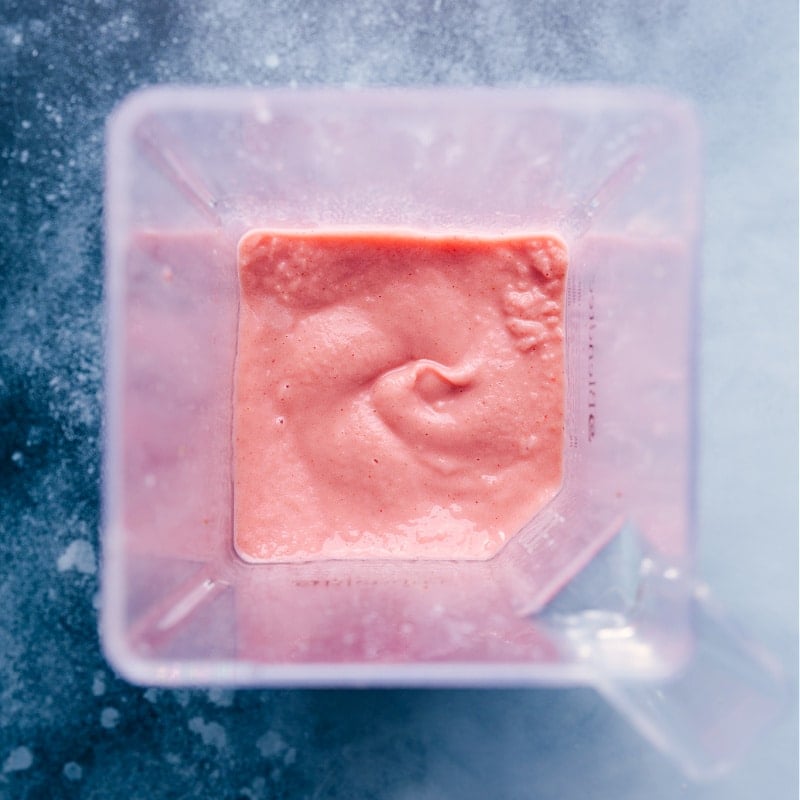 Jamba Juice copycat Strawberry Wild smoothie recipe! Recipe via ChelseasMessyApron #breakfast #quick #easy #simple #best #healthy #dessert #ice #jambajuice #strawberry #wild #smoothie Overhead view of the finished smoothie, still in the blender jar.