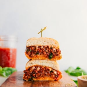 Italian Sausage Sandwich cut in half and stacked on top of each other showing the delicious insides.