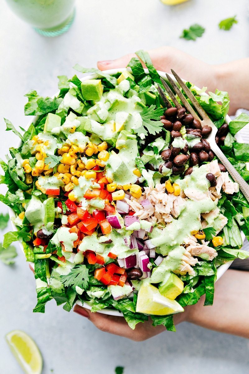 No wonder Cafe Rio Dressing is all the rage in the States -- is there anything better than this creamy cilantro-lime dressing?! Recipe via ChelseasMessyApron #side #best #quick #easy #salad #copycat #caferio #saladdressing #dressing Overhead image of Cafe Rio Dressing drizzled over a salad