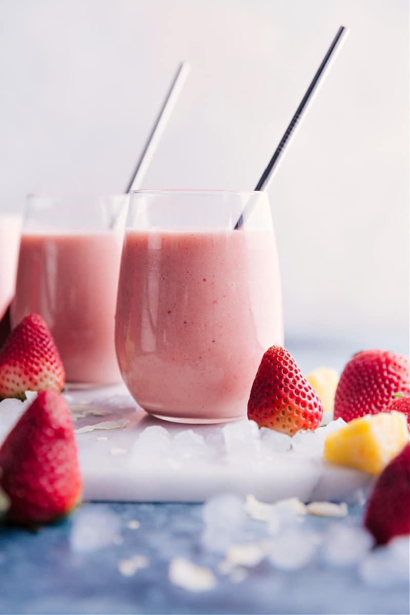 This tasty Strawberry Piña Colada smoothie is a creamy, sweet, frozen drink with coconut, pineapple, and strawberries. Adding strawberries makes for a fun and unique take on the classic frozen Pina Colada. (This beverage is non-alcoholic.) Recipe via chelseasmessyapron #breakfast #quick #easy #simple #delicious #snack #pineapple #tropical #best #frozen #strawberry #pinacolada #smoothies Strawberry Piña Colada smoothies.