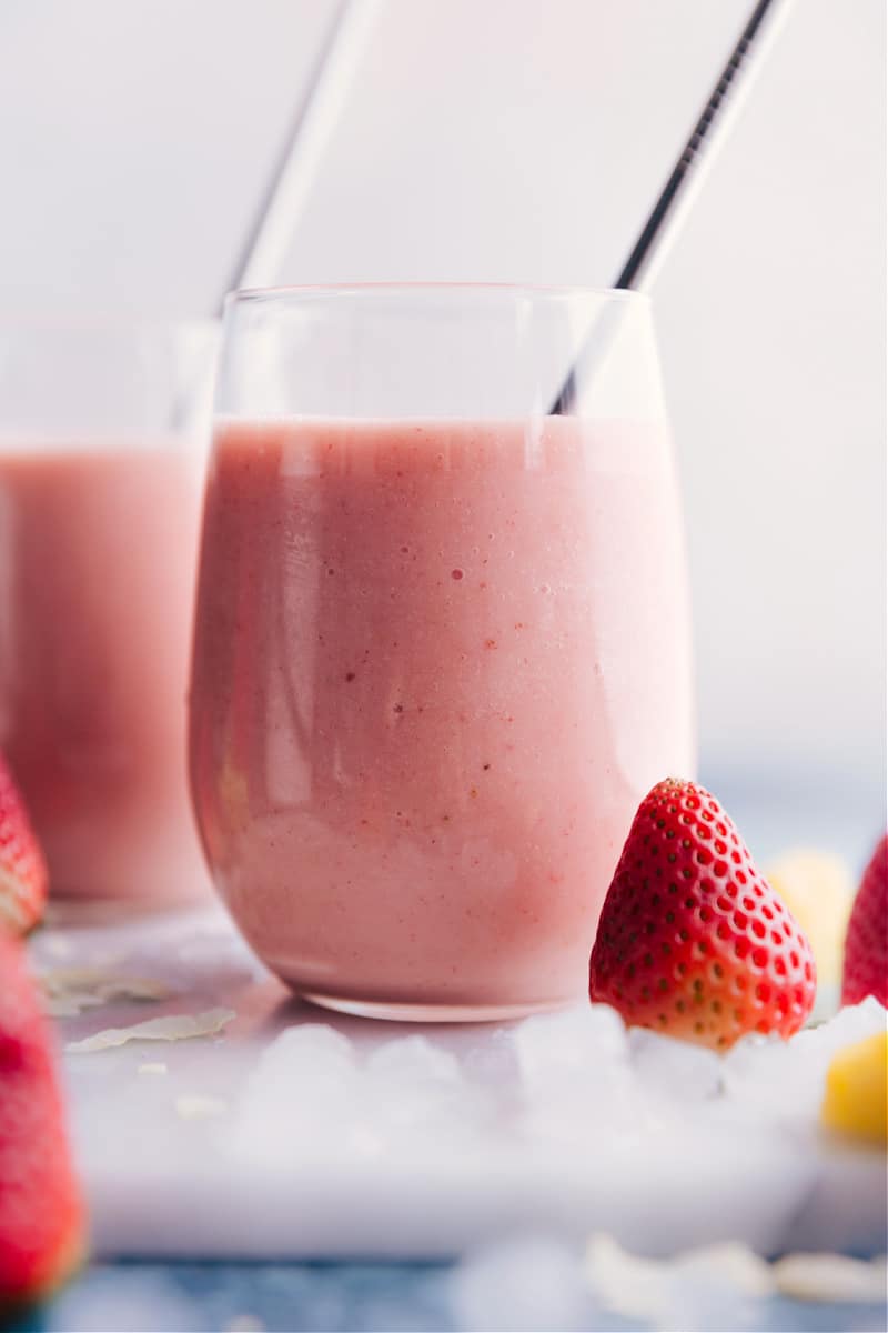 The best ever Strawberry Piña Colada smoothie is a creamy, sweet, frozen drink with coconut, pineapple, and strawberries. Adding strawberries makes for a fun and unique take on the classic frozen Pina Colada. (This beverage is non-alcoholic.) Recipe via chelseasmessyapron #breakfast #quick #easy #simple #delicious #snack #pineapple #tropical #best #frozen #strawberry #pinacolada #smoothies Strawberry Piña Colada smoothies.