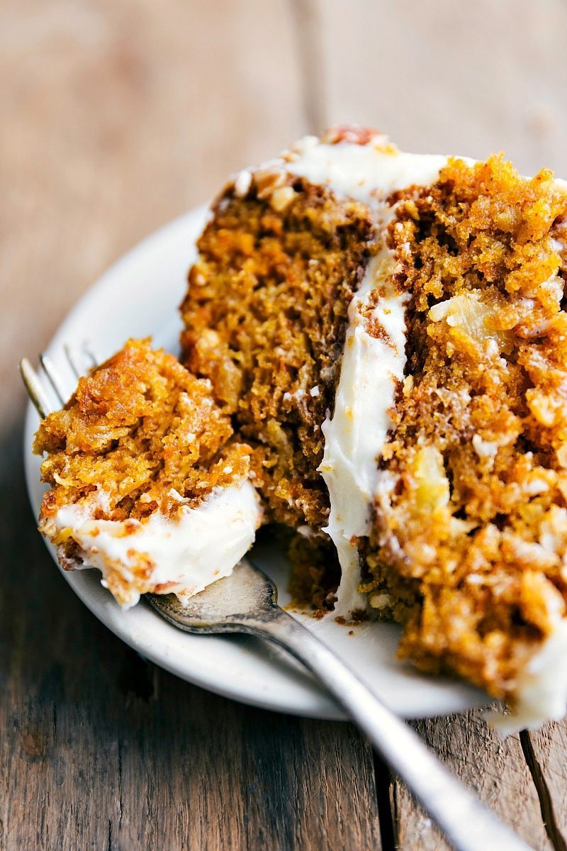 Flavorful Pumpkin Carrot Cake Slice with Icing and a Bite Taken A slice of carrot and pumpkin cake with a bite taken out of it, packed full of flavor and perfectly complemented by the icing.