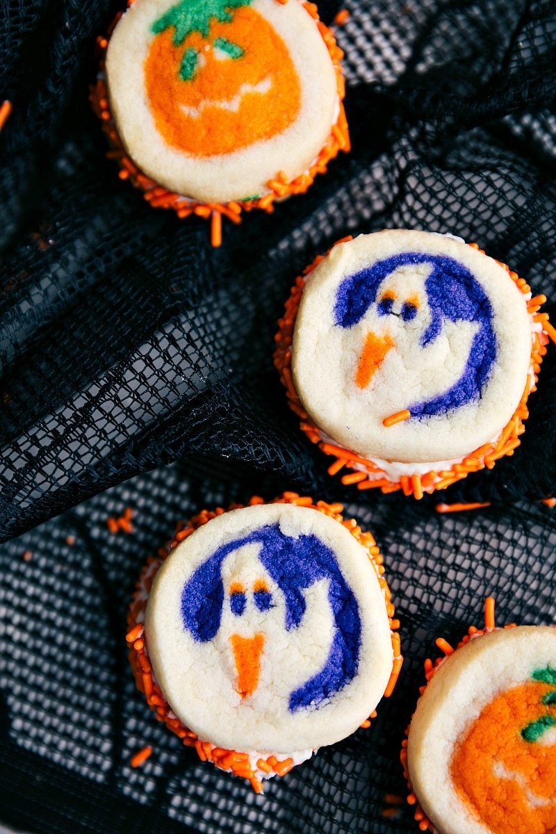 DOUBLE SIDED HALLOWEEN COOKIES | 5 super easy Halloween treat ideas -- mummy cookies, graveyard pudding cups, Frankenstein krispies, pumpkin krispies, and double-sided Halloween sandwich cookiesย I chelseasmessyapron.com Image of 4 double sided halloween cookies with pumpkins and ghosts on them. These go along nicely with the other halloween treat ideas