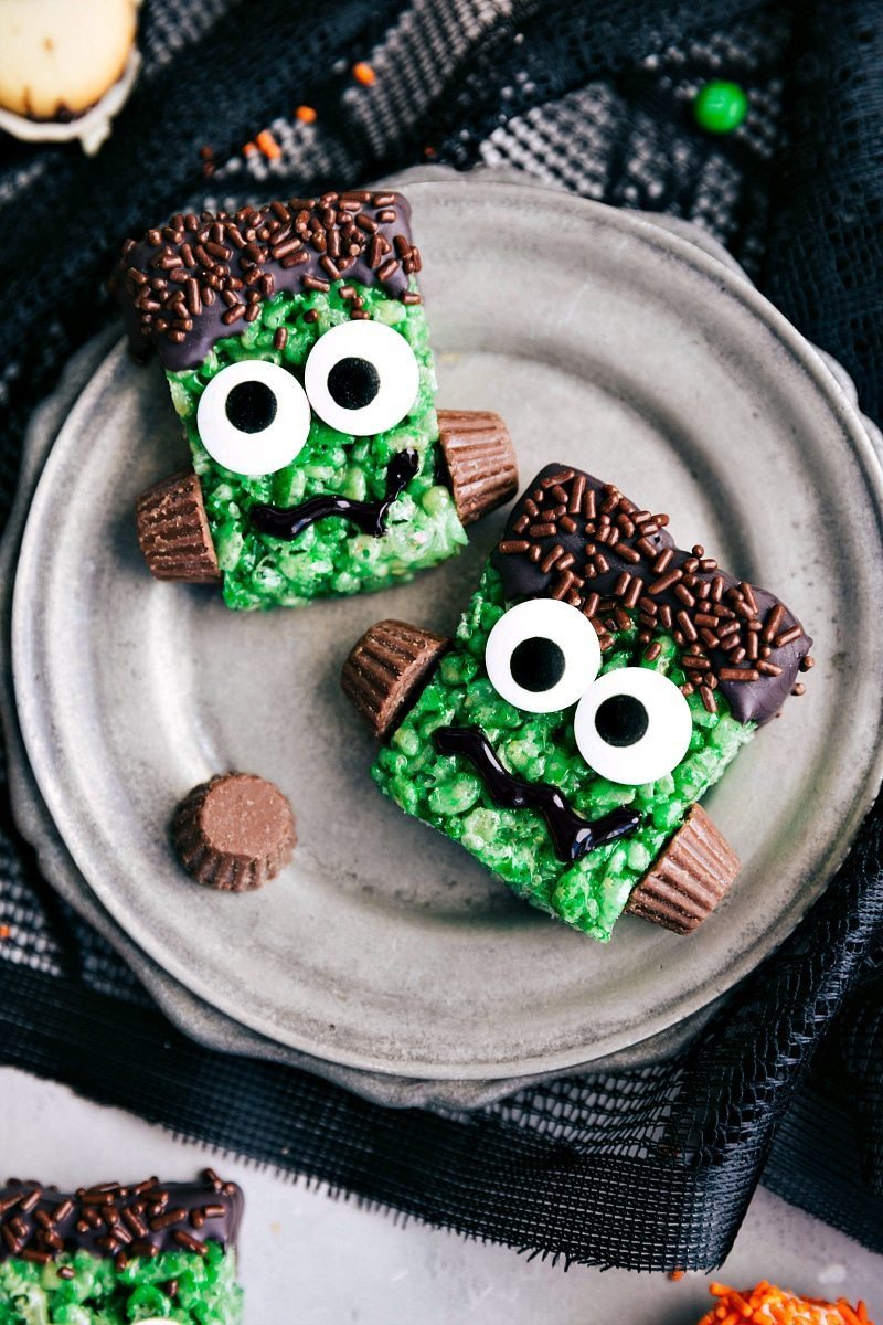 FRANKENSTEIN KRISPIES TREATS | 5 super easy Halloween treats -- mummy cookies, graveyard pudding cups, Frankenstein krispies, pumpkin krispies, and double-sided Halloween sandwich cookies. They are also perfect for a fun Halloween night in so you don't find yourself having to look up "Halloween Trick or Treating near me" I chelseasmessyapron.com Image of two of the Frankenstein krispies treats that go with these treats to make for Halloween