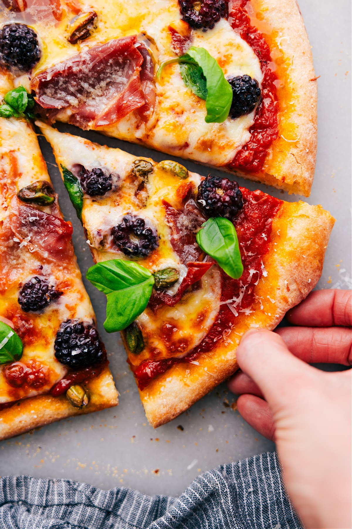 How To Make Blackberry Basil Pizza A slice of the delicious pizza fresh out of the oven.