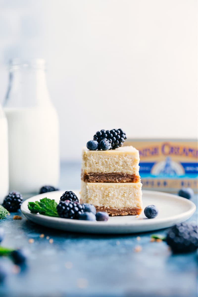 Smooth, creamy, and indulgent vanilla Cheesecake Bars with a thick, sweet graham cracker crust. Plus, suggestions for how to top your cheesecake bars -- add a few berries, a simple berry sauce, caramel sauce, or caramelized sugar topping -- all these ideas are outlined in the post. Enjoy! Recipe via ChelseasMessyApron #dessert #quick #easy #simple #best #vanilla #crust #berries #butter #cheesecake #bars Image of the stacked cheesecake bars