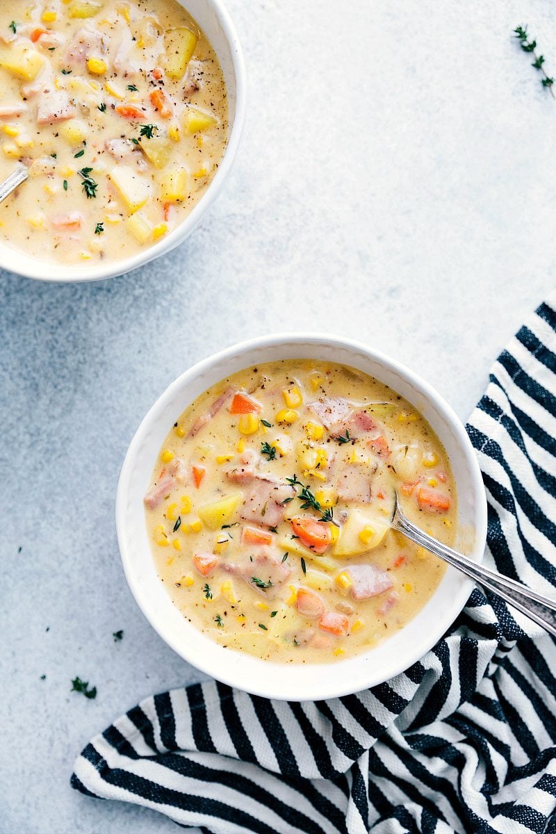 Bowls of Comforting Ham and Potato Soup, Ready to Savor Two bowls of steaming ham and potato soup, rich and hearty, ready for consumption.