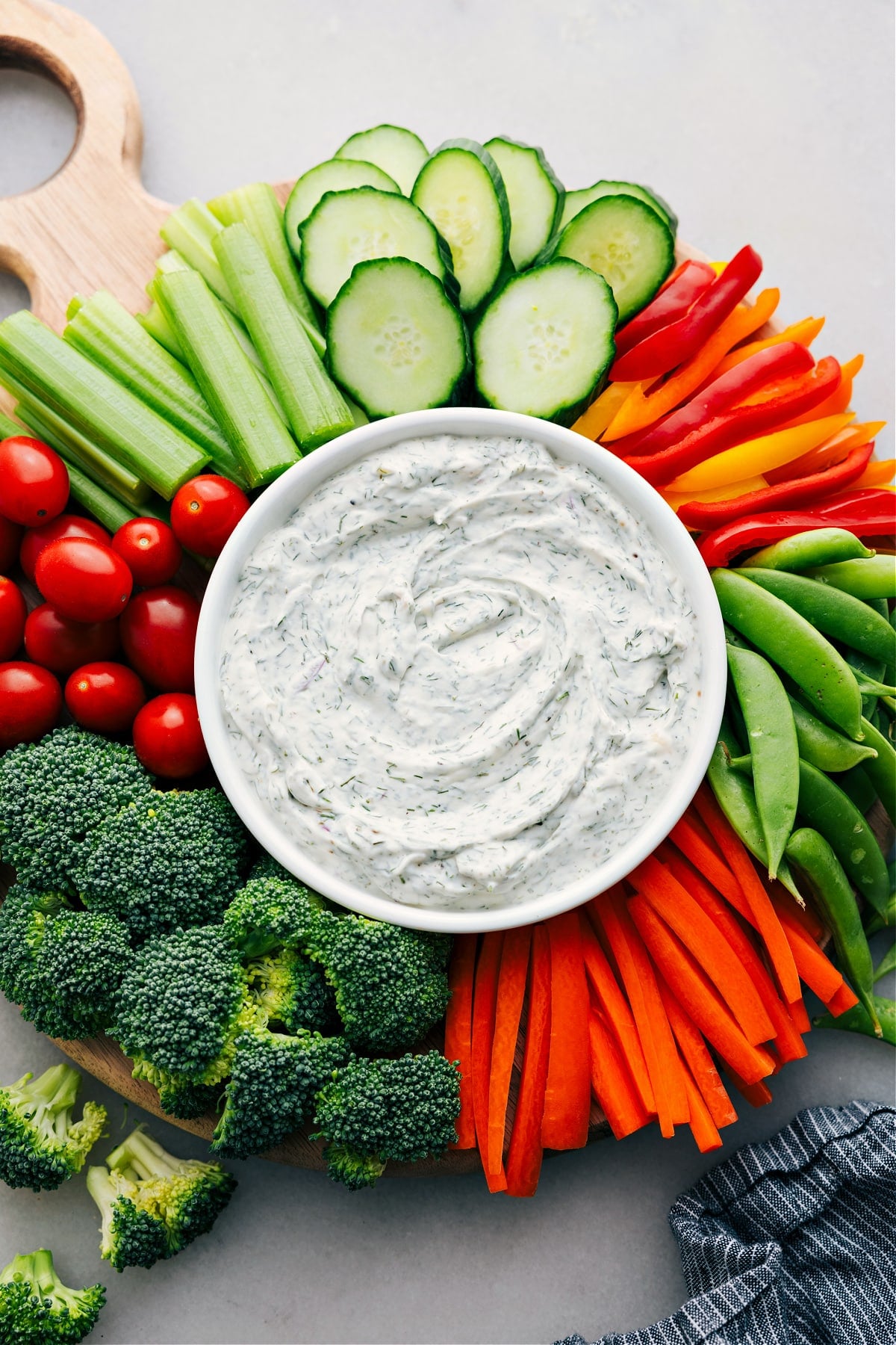 Easy And Delicious Vegetable Dip Recipe For Hosting A platter of veggies surrounds a bowl of veggie dip in the center, all set for hosting or snacking.