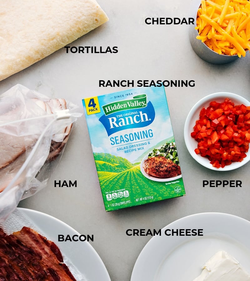 Ham And Cheese Pinwheels Ingredients All the ingredients in this recipe prepped out for easy assembly including the tortillas, ham, bacon, ranch seasoning, cream cheese, peppers, and cheese.