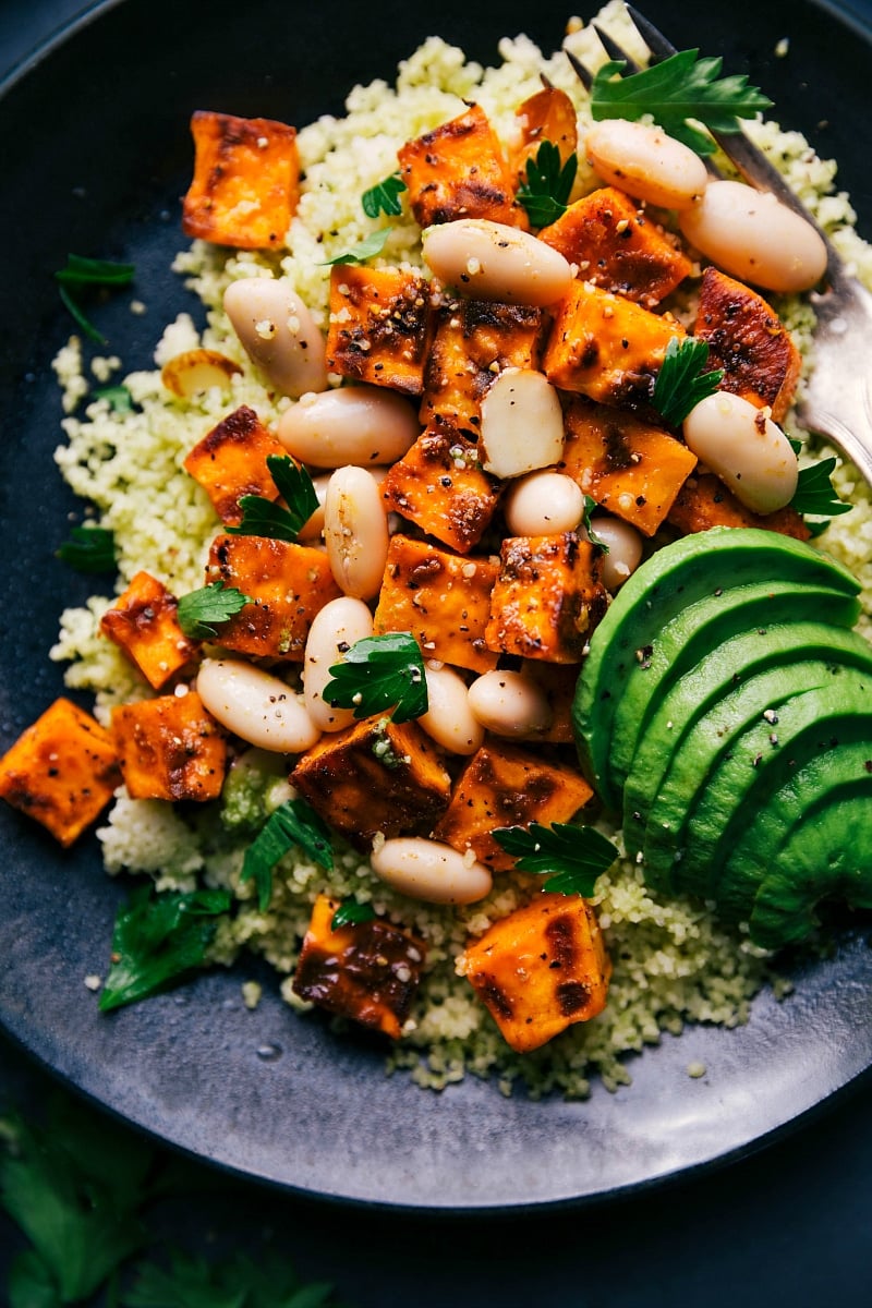 Ready to Enjoy - Couscous and Sweet Potato Dish with Fresh Herbs Couscous and sweet potato recipe garnished with fresh herbs and seasonings, served and ready to eat.